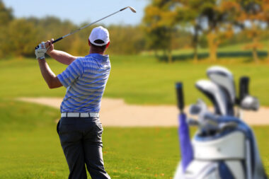 Golfer having just hit the golf ball on a golf course