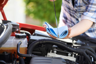 A person performing an engine oil check