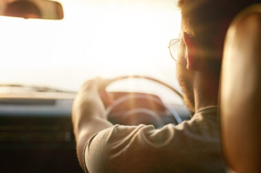 Person driving with sun beaming through the windscreen