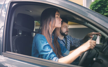 Two people in a car with the driver driving cautiously