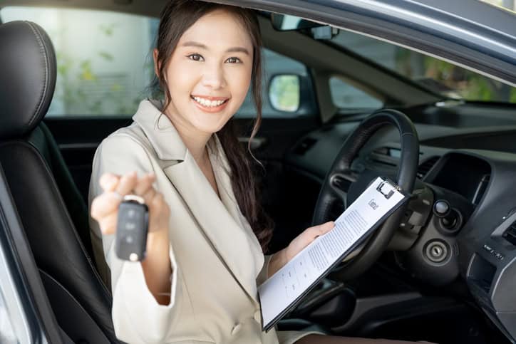 woman holding car keys inside a car