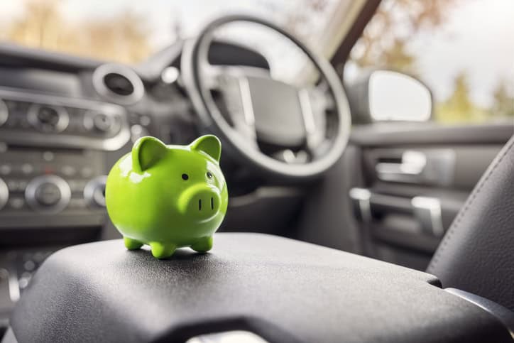 green piggy bank inside a car