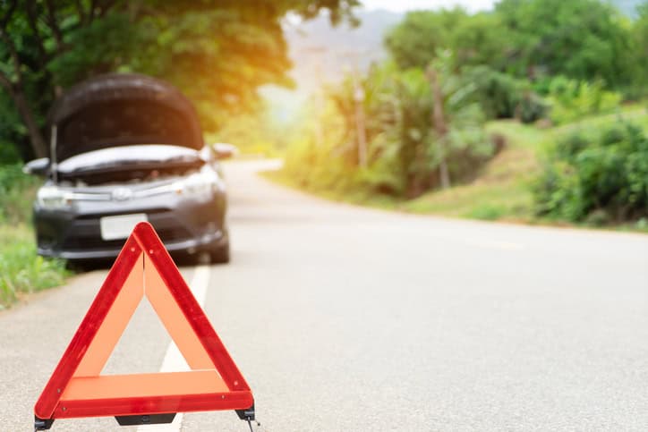 Car broken down on the road with emergency help sign